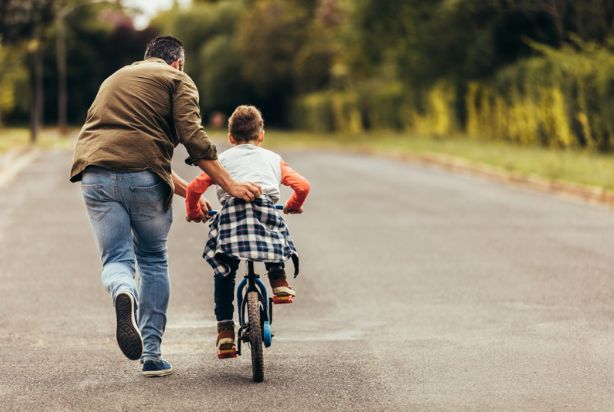Pai ensinando o filho a andar de bicicleta