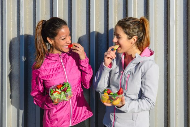 Duas mulheres comendo frutas e verduras