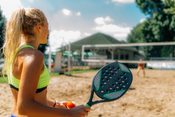 Mulher segurando a raquete de beach tennis
