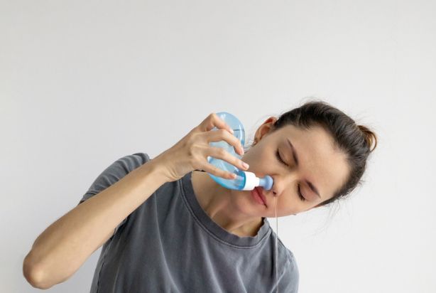 mulher fazendo lavagem nasal