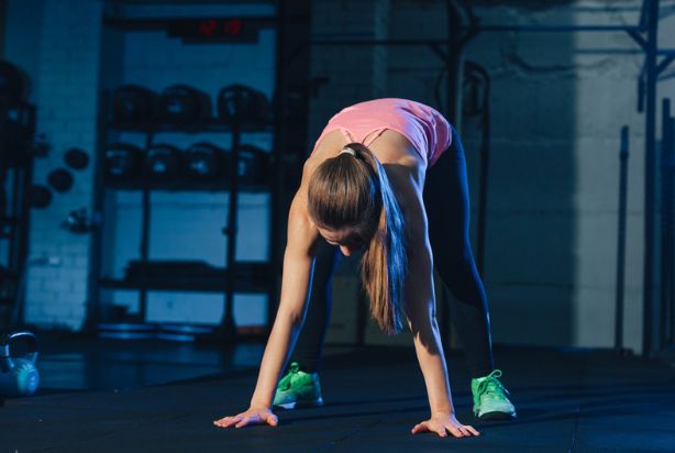 mulher fazendo o movimento do burpee